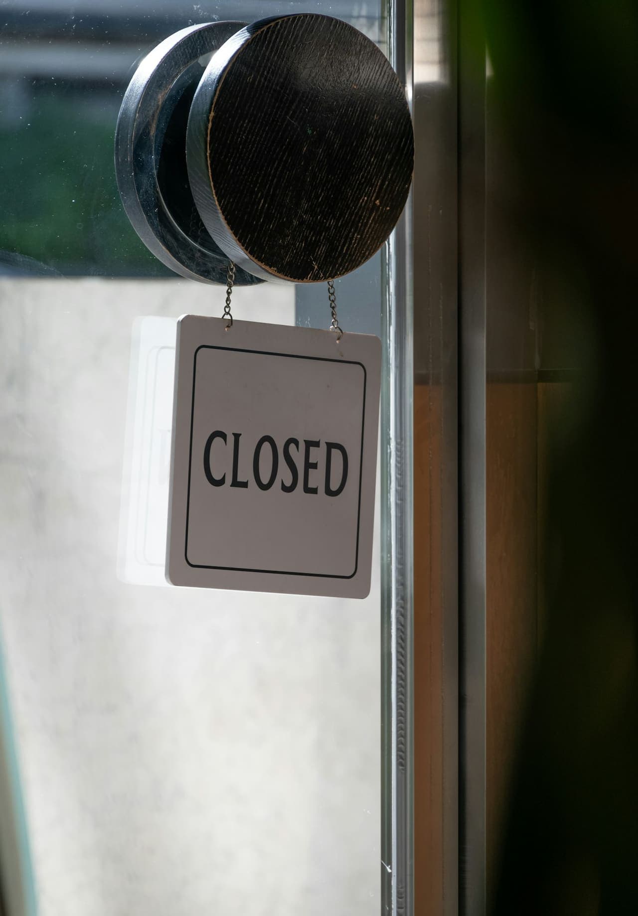 Closed sign hanging on a glass business door
